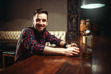 Smiling man sitting at the bar counter, 