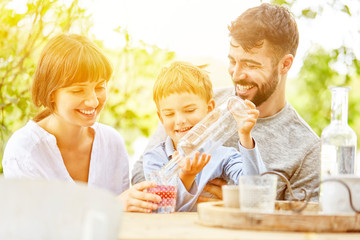 Sohn gießt Eltern Wasser in Glas ein