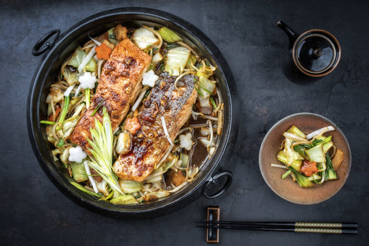 Japanese chan chan yaki hot pot with salmon fillet as top view in traditional cast iron pot