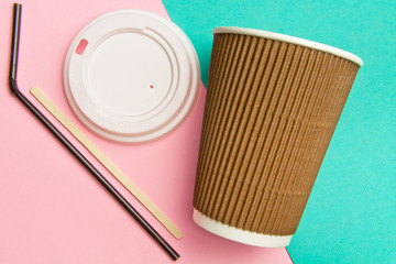 Disposable cups for hot drinks wand and tube on a geometric pink and turquoise backgrounds. Paper cups set