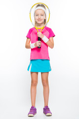 Cute little girl with tennis racket in front of her head on white background