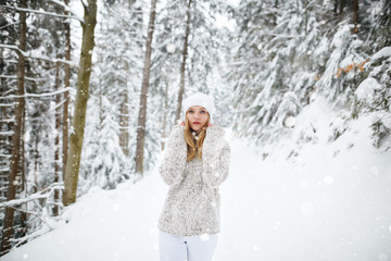Beautiful blond hair girl i winter clothes. Beautiful winter portrait of young woman in the winter snowy scenery. Happy winter moments