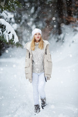 Happy young woman walking in winter time. Happy girl having fun in the snow. Snow covered trees in the winter sun light. Snowy pine trees on a winter landscape