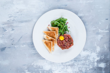 Tartarus on a white plate is shot against a background