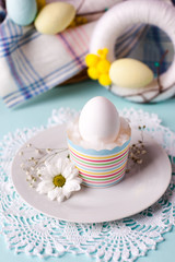 an egg in a stand with floral elements - elements of the Easter festive table, an option for serving