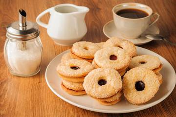 Cookie with jam of homemade baking in white plate on a wooden table closeup. Unhealhy food for your figure.