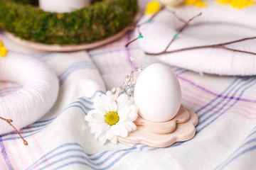 egg in a wooden stand with floral elements - elements of the Easter festive table, serving option