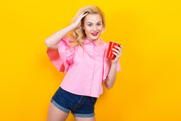 Blonde woman in pink blouse with red cup