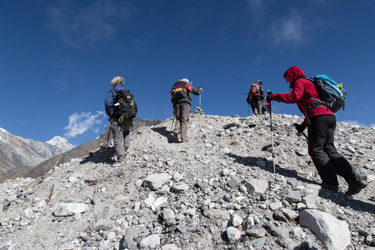 Wanderer &uuml;berqueren den Ngozumba Gletscher im Himalaya auf dem Weg zum Cho La Pass, Everestgebiet, Nepal