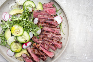 Traditional barbecue skirt steak sliced with salad and avocado as close-up on a plate with copy space right