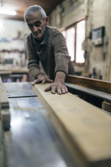 Close up shot of old master carpenter working in his woodwork or workshop