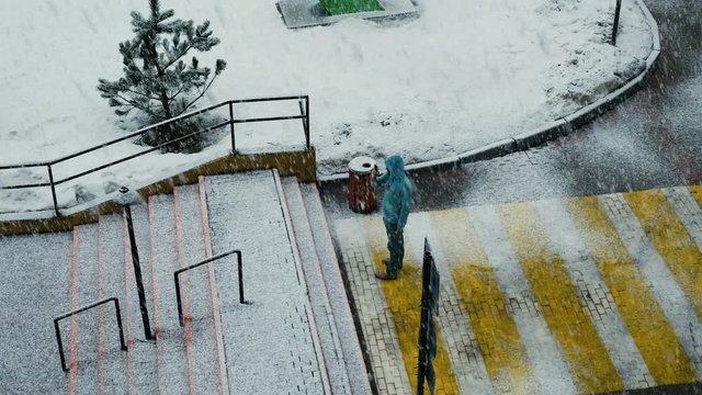 A man takes a snowfall on the phone, stands under the snow, 4k.
