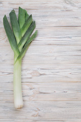 Leek onion on the wooden table. Top view and flat lay.