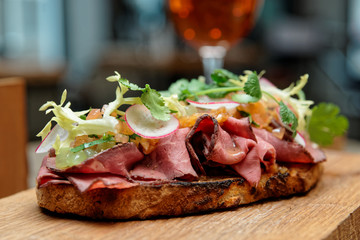 Sandwich with roast beef on restaurant table, close-up