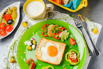 Egg in toast bread baked in the shape of a flower with fresh vegetables and yogurt