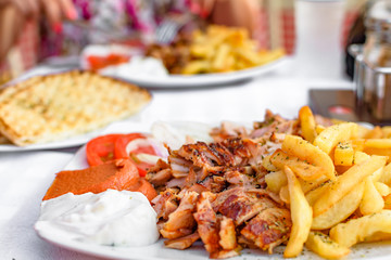 Greek gyros on a plate with French fries and vegetables