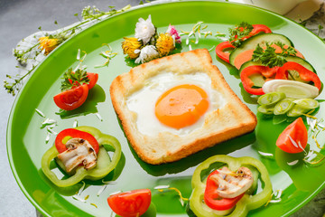 Egg in toast bread baked in the shape of a flower with fresh vegetables and yogurt
