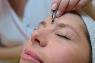 grooming eyebrows in a beauty salon