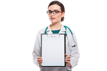 Young woman doctor with stethoscope holding and showing clipboard in her hands in white uniform on white background