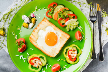 Egg in toast bread baked in the shape of a flower with fresh vegetables