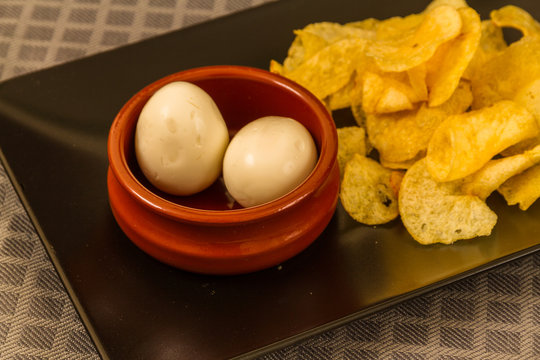 Two pickled eggs with crisps or chips