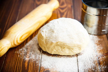 fresh raw dough with a rolling pin