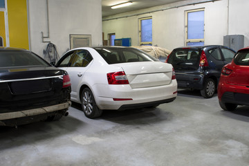 Cars in a workshop waiting to be repaired.