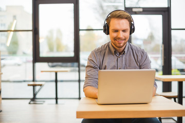 Handsome cheerful man wearing headphones