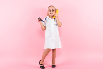 Little girl in doctor costume with banana