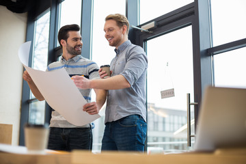 Cheerful smart engineers working together