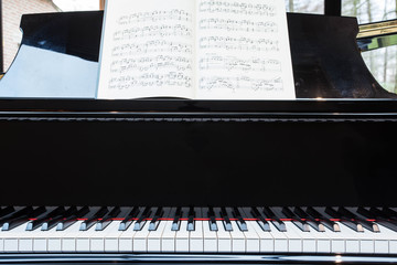 Grand black piano with music sheet