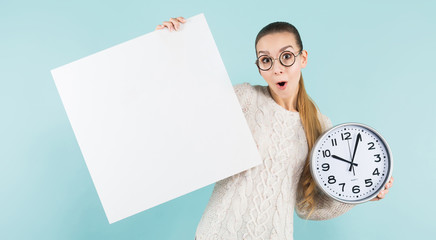 Attractive young woman with blank banner and clock