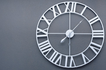 wall clock with roman numerals on white on gray wall