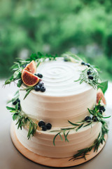 Rustic wedding cake decorated with figs and greenery rosemary.