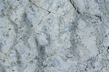 Natural stone grunge grey wall with cracks.