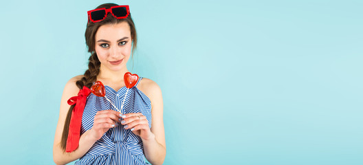 Young woman with heart-shaped lollipops