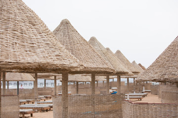 Wooden straw umbrellas on a tropical beach