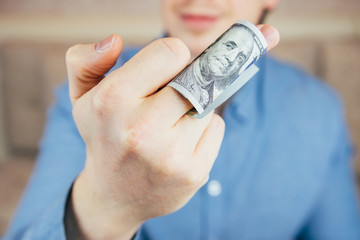 Man shows middle finger with dollar bill on it. Concept of bribe, dishonesty, hypocrisy