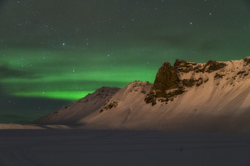 Fototapeta na wymiar Aurora borealis over the mountains is Iceland