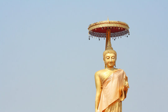Standing Buddha image on light blue  sky background at doi ti temple, Lumphun ,Thailand