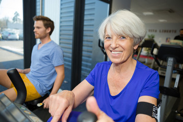 Fototapeta na wymiar smiling female senior exercising in gym