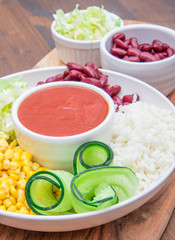 vegan dish with rice,red beans , corn and cucumber