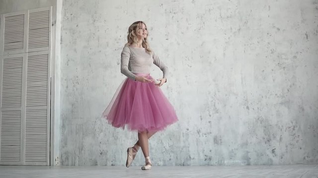 ballet dancer in a pink tutu and pointe shoes. beautiful young ballerina at a rehearsal. lightness and grace of the ballet. slow motion