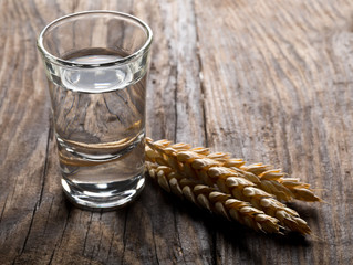 German hard liquor Korn Schnapps in shot glass with wheat ears © Shawn Hempel