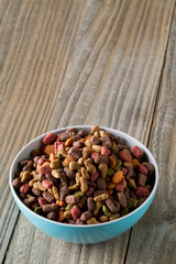 Heap of dry pet food in blue plastic bowl