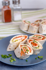 Rolls of thin pancakes with smoked salmon, cream cheese, chives and lettuce.