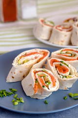 Rolls of thin pancakes with smoked salmon, cream cheese, chives and lettuce.