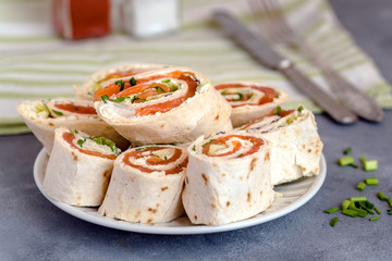 Rolls of thin pancakes with smoked salmon, cream cheese, chives and lettuce.