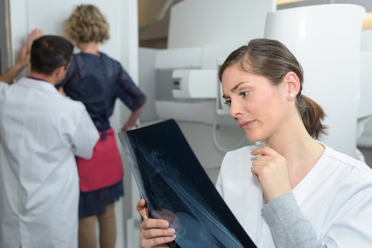 female doctor checking xray image  being very concerned