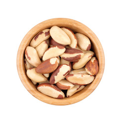 Fototapeta premium Brazil nut in wooden bowl isolated on white. Top view.